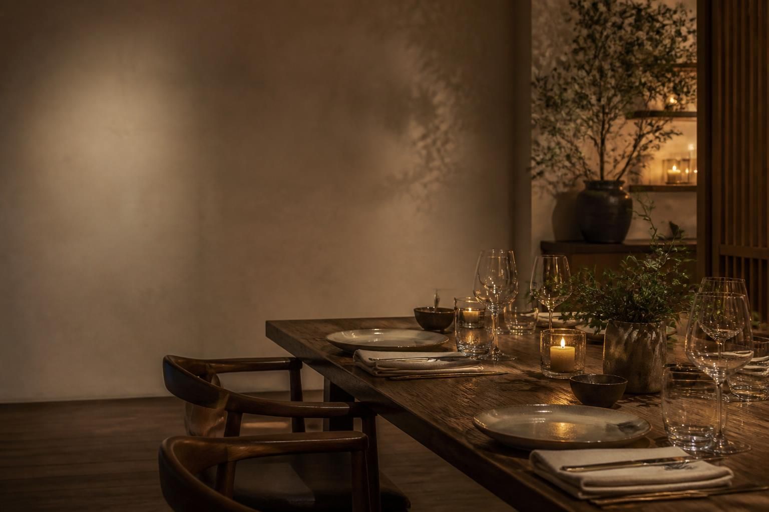 Warm candlelit private dinner table with polished tableware and open space